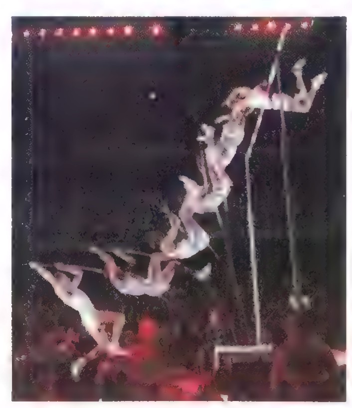 A time-sequence photograph of a pole vaulter arching over the bar in a stadium.