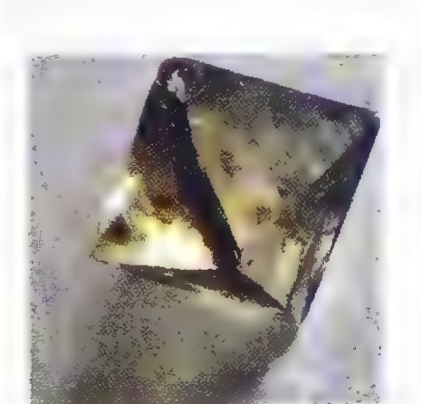 Photograph of a cubic fluorite crystal, whose triangular faces appear distorted by perspective.