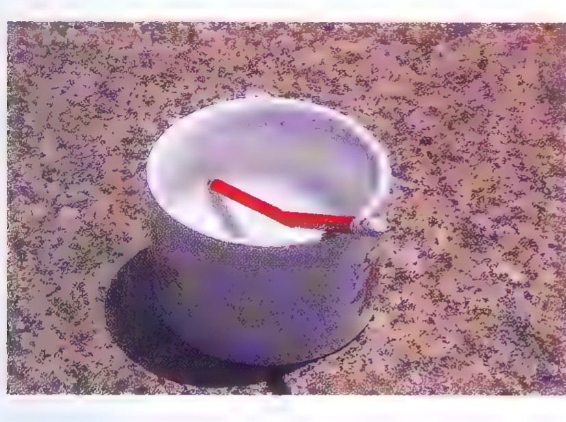 Photograph of a red pencil standing in a white cup of water, its underwater portion appearing shifted sideways.