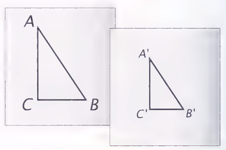 Two sheets of paper side by side, one with a large triangle ABC and the other with a smaller copy labelled A′B′C′.