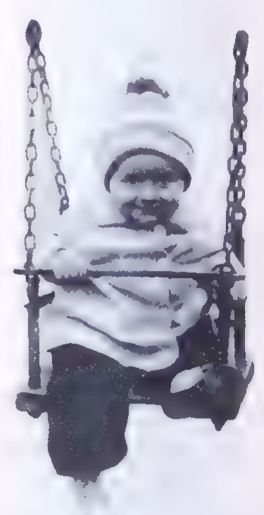 Photograph of a small child sitting in a swing seat suspended by chains.
