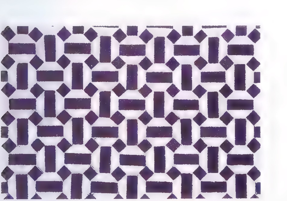 A photograph of a Moroccan mosaic tile wall in dark blue and cream, in a repeating geometric pattern.