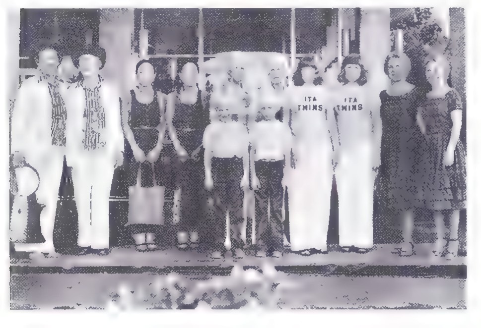 Black-and-white photograph of a group of people posed in rows on steps, taken with a wide-angle camera.