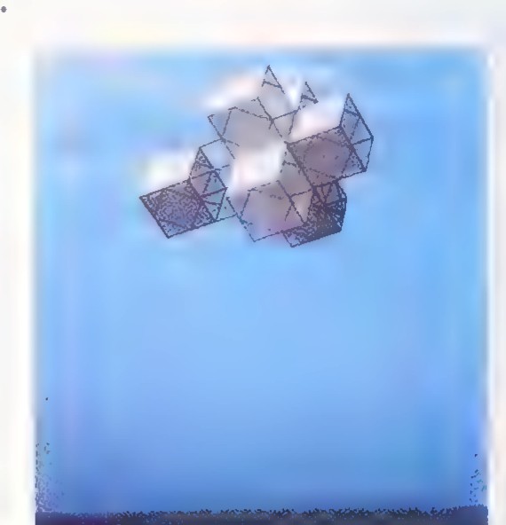Photograph of a kite shaped like a hypercube: a cluster of cubes against a blue sky.