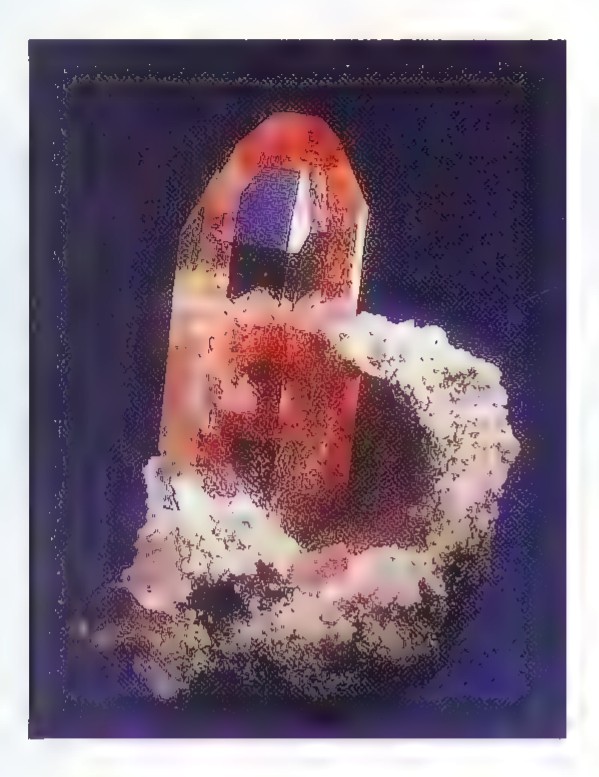 Photograph of a topaz crystal: a transparent orange-brown crystal embedded in white rock.