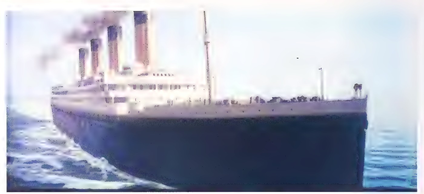 Photograph of a large ocean liner, a model of the Titanic, moving through calm water.